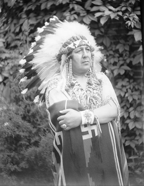 Posed outdoor portrait of Ho-Chunk Chief Silver Tongue in front of foliage