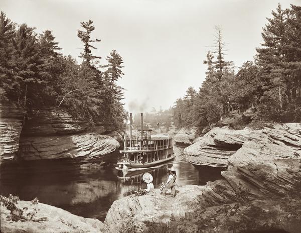 View of "Apollo No. 1" Steamboat in Narrows from Devil's Elbow. Two girls are looking out at the steamboat from rocks in the foreground.