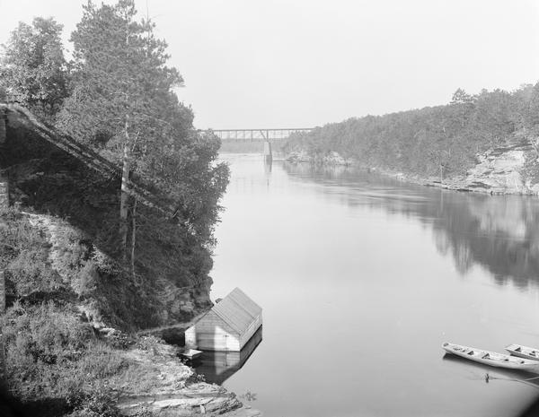 Elevated view of point across from Ravine Bridge. Left section of panorama. There are boats in the river. Small building at left, bridge in distance.