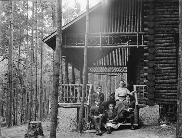 Unidentified family sitting on the steps of the Bird's Nest Resort.