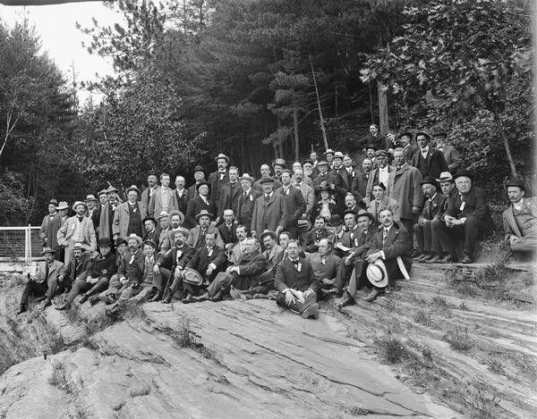 Group of men and one woman posing on rocks.