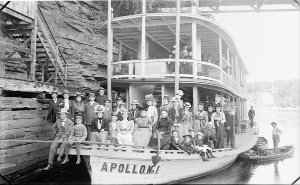 Passengers posed on the bow of the "Apollo No. 1" steamboat. A bridge in the background is at the top of the image.