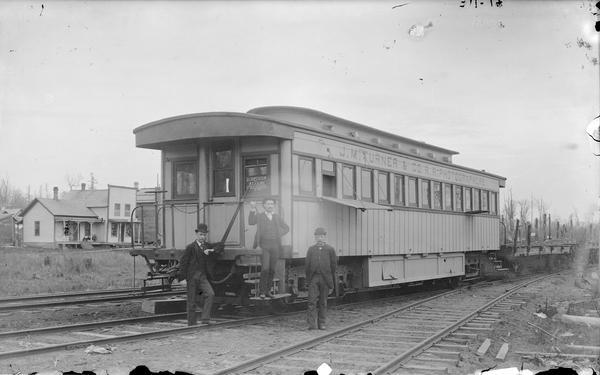 Three men posing with the J.M. Turner and Company Railroad Photographer's Car.