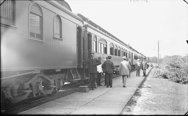 Unidentified group of train ticket agents standing near train. Special excursion.