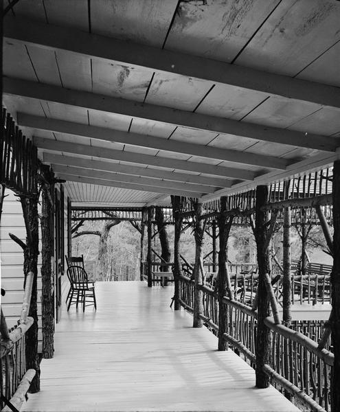 Unidentified porch with rustic railings, and chairs.