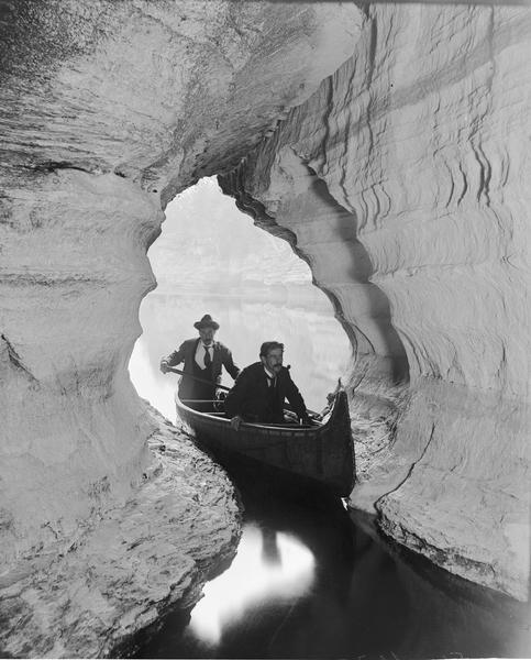 View from Boat Cave out to the river, with two men in a canoe in the foreground.