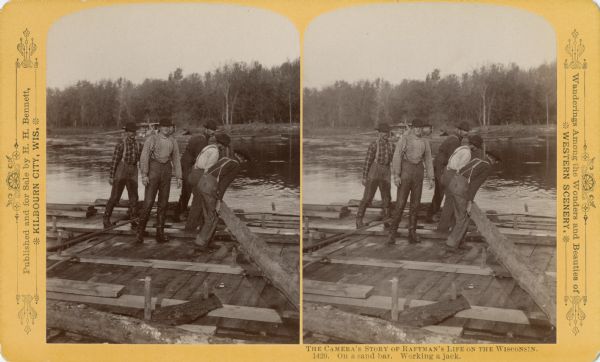 Stereograph of five raftsmen working a jack on a sandbar.