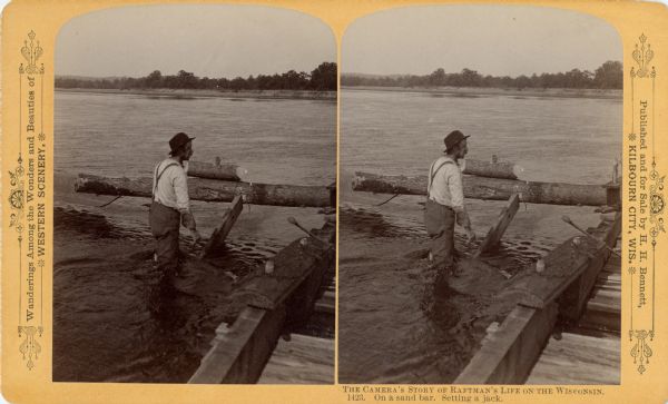 Stereograph of a raftsman standing in water on sandbar setting a jack.