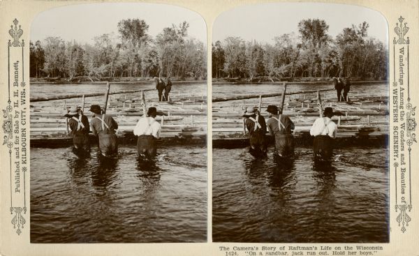 Stereograph of three raftsmen standing in the river, probably on a sandbar, using wooden poles to hold or push against the rafts.