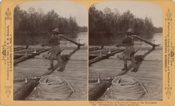 Stereograph of a man on raft holding end of oar at chest level. There is rope coiled in the foreground.