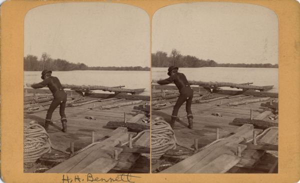 Stereograph of photographer Henry Hamilton Bennett pulling an oar on a Wisconsin raft.