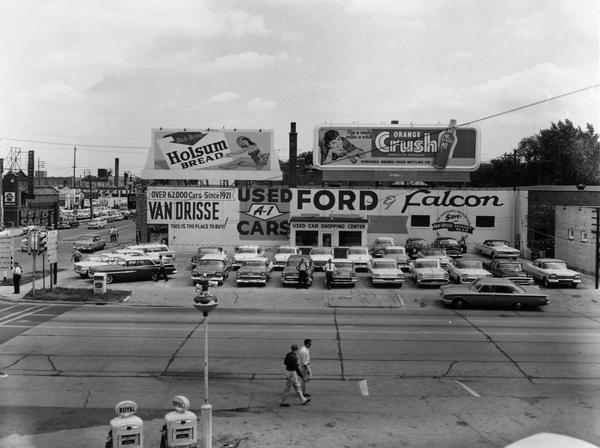 Elevated view of used car lot of Van Drisse Motors, a Ford dealer, at the intersection of Main and Monroe Streets.