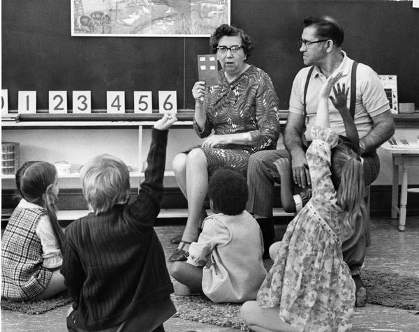 Early childhood classroom in which two volunteer teachers are instructing children.