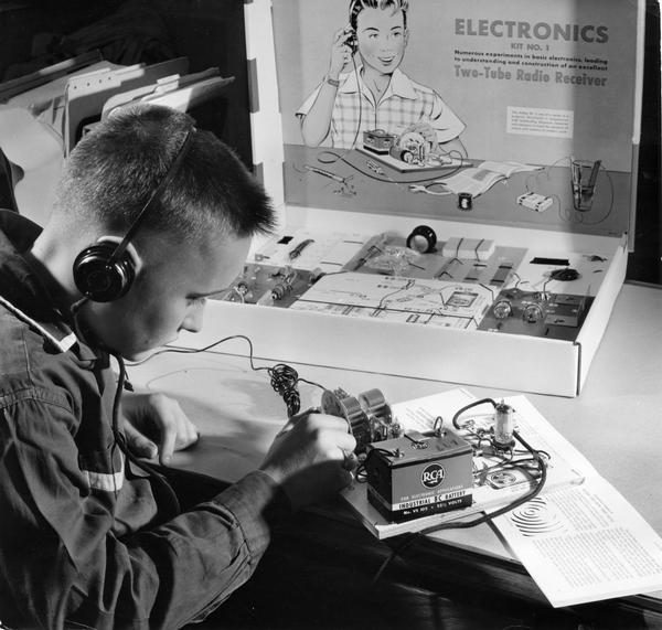 Boy with radio kit, experimenting with a two tube radio receiver.