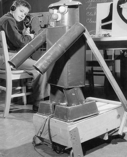 John Fischer, age 11, demonstrates his invention, a "walking and talking" robot. The robot's eyes light up, and it rolls back and forth on a platform.