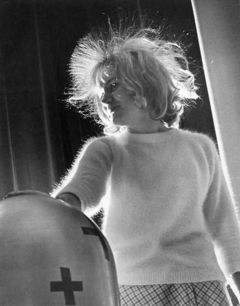 Gail Lukas' hair stands on end when she places her hand on a Van de Graalf generator in a demonstration by the Atomic Energy Commission for junior high school students.