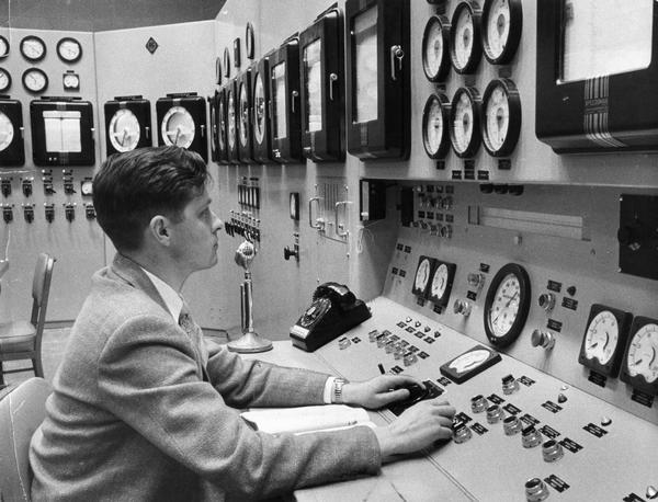 The operator of a nuclear plant sits in the control room.