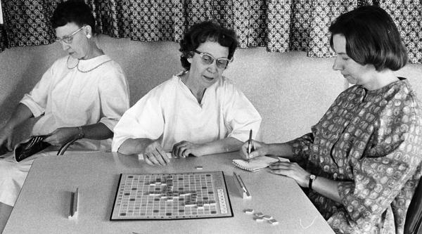 A hospital patient plays a scrabble game with an occupational therapist.