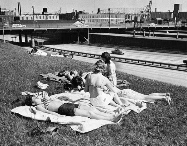 Women sun bathe near an express highway in Milwaukee.