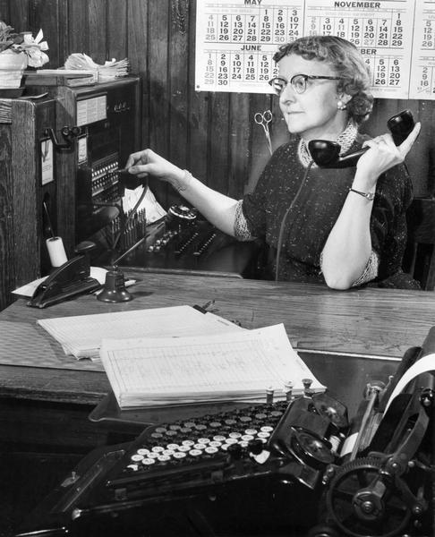Female telephone switchboard operator at work.