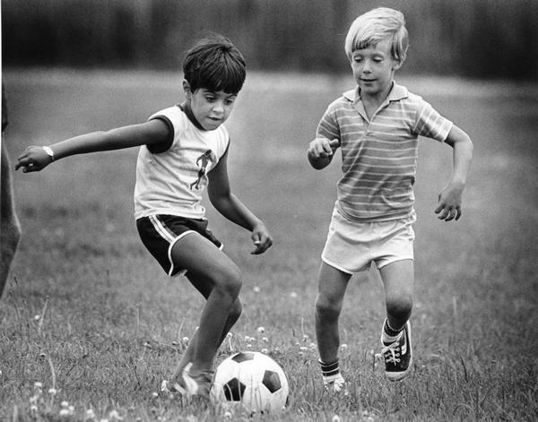 Two young boys in action playing soccer.