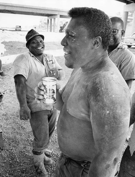 Construction workers enjoying a beer after pouring concrete for a bridge structure.