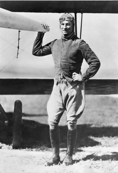 General William "Billy" Mitchell posing next to an airplane wearing flight gear.