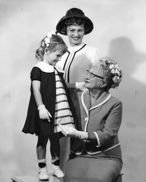 A grandmother with daughter and granddaughter. They are nicely dressed for mother's day.