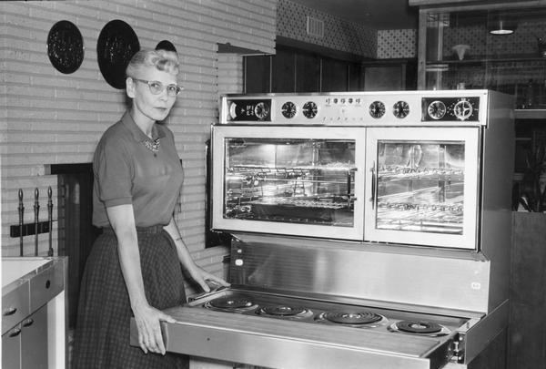 Woman displays a brand new oven/stove.