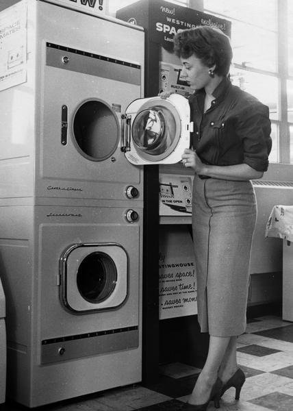 Woman demonstrating a new space-saving Westinghouse washer/dryer unit.