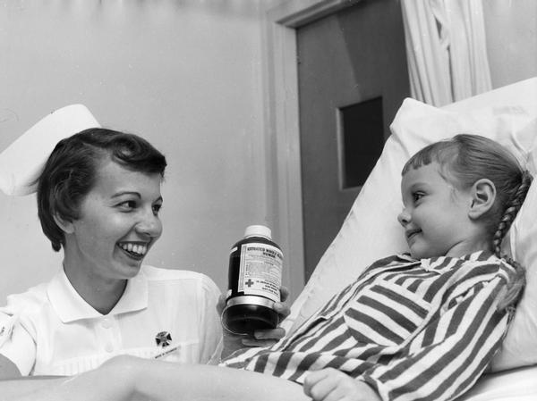 Nurse with a young girl patient and a container of blood.
