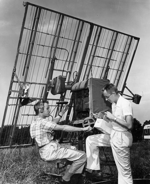 Meteorologists using radar equipment outdoors.