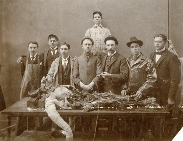 Students surround a partially-dissected cadaver at the Chicago College of Dental Surgery.