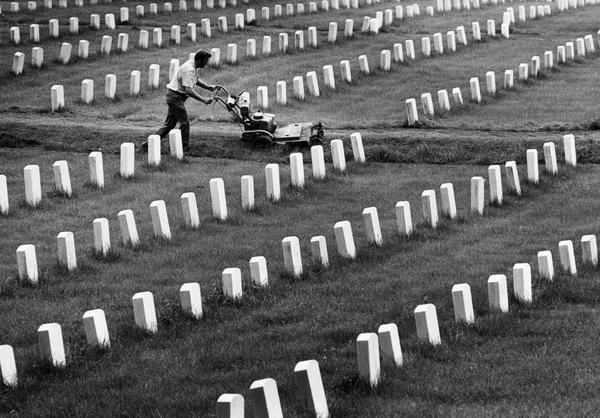 Slightly elevated view of a man mowing the lawn at the Veterans' Administration Wood National Cemetery.
