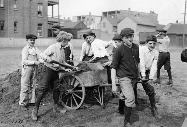 Young boys digging a garden in an urban setting on "Mowhawk Street near Larrabee." Original caption reads: "Newberry School boys who have gotten into the harness and are actively engaged in the work of cleaning up a plot of ground loaned by the Board of Education for raising a garden."