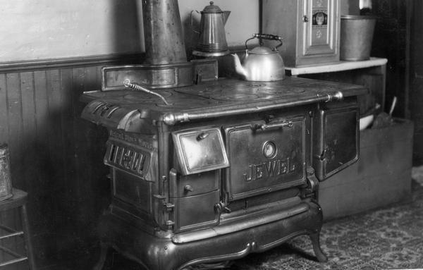 "Jewel" brand stove inside a farmhouse kitchen. The original caption reads: "Stove for patch work in making faked pictures."