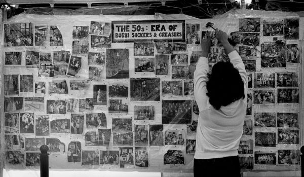 A woman finishes a display of Bay View High School photographs from the 1950s as part of an any-year reunion at the Festa Italiana on the Summerfest grounds.