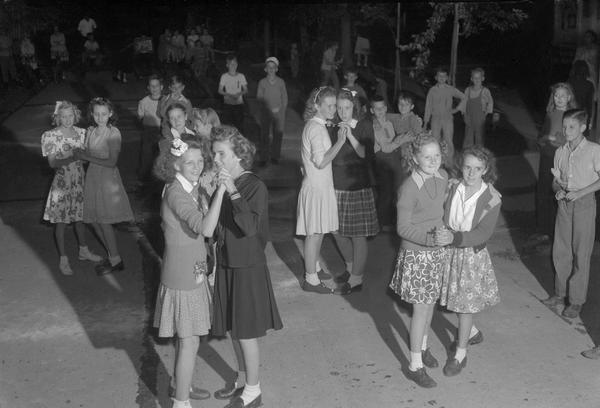 Young people dance in the street on Bowen Court as part of city Recreation Department summer activities. Girls are dancing with girls and boys are dancing with boys.