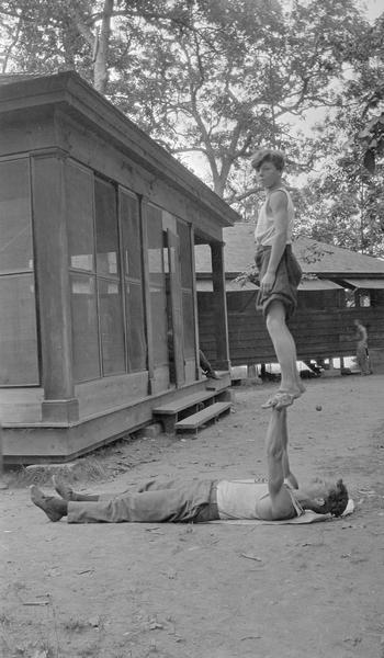 Boys demonstrate acrobatic skills on the grounds of their summer camp.