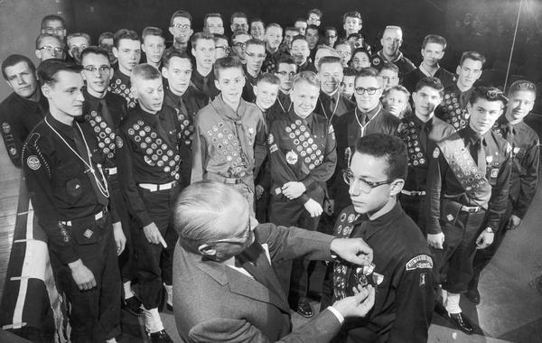 Boy Scouts and Explorer Scouts receive the Eagle Scout rank or the Explorer Silver Award, scouting's highest awards at a scouting court of honor ceremony.