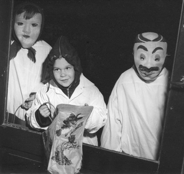 Carl Lueders' children stand at the door and trick-or-treat in their neighborhood on Halloween.
