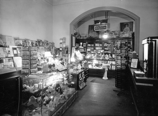 Interior of a small variety store. Racks of cards, stuffed animals, and gift items are on display.