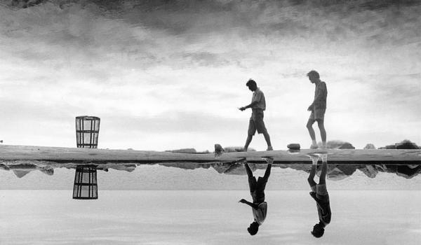 Two men walking along the edge of Lake Michigan.