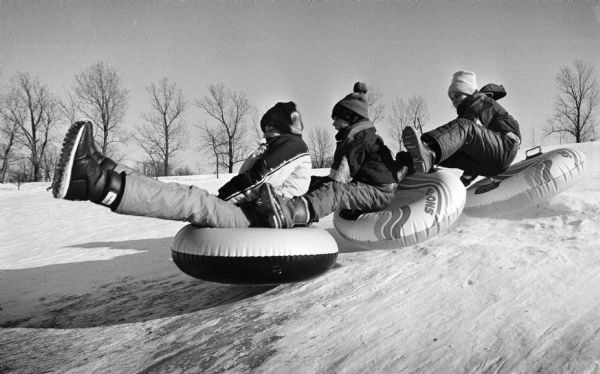 Bundled-up boys ride their tubes down an icy slope in Mee-Kwon Park.