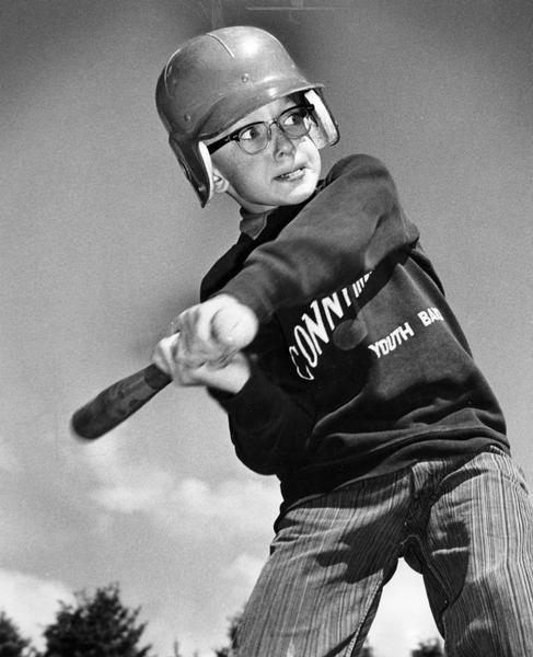 Helmeted boy swings a bat at city of Brown Deer's recreation department baseball camp.