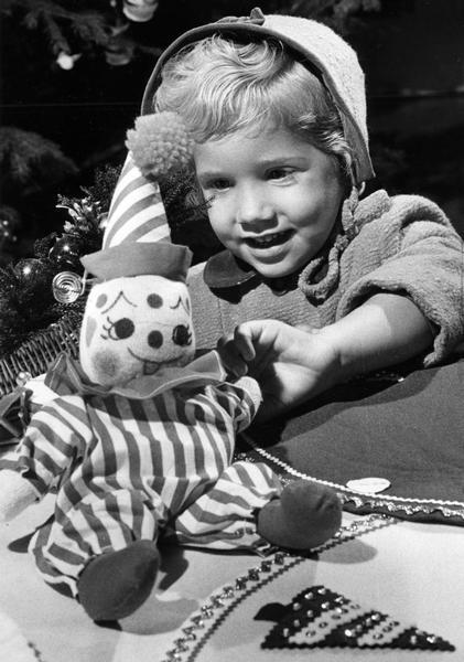 A young girl handles a stuffed toy clown during the Milwaukee-Downer seminary alumnae holiday bazaar.