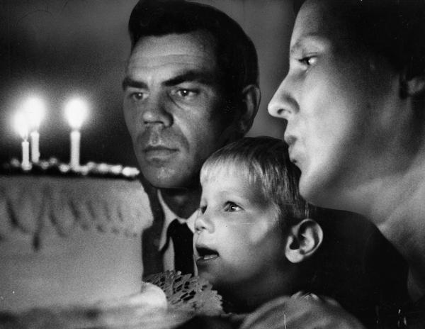 Father, mother and daughter all celebrate their special birthday with three candles on one cake.