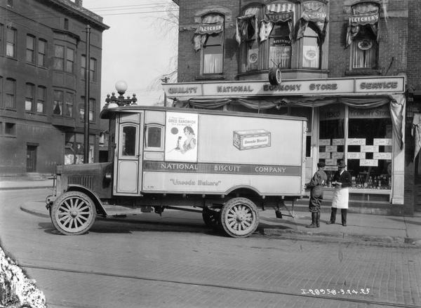 International Model 43 motor truck delivering goods for the National Biscuit Company to the National Economy Store.  Truck was owned by William Millard and equipped with National Biscuit Company Body.  Mr. Millard delivered goods to five counties on a special route for the biscuit company. The truck's side panel includes advertisements for Oreo cookies and Uneeda biscuits.