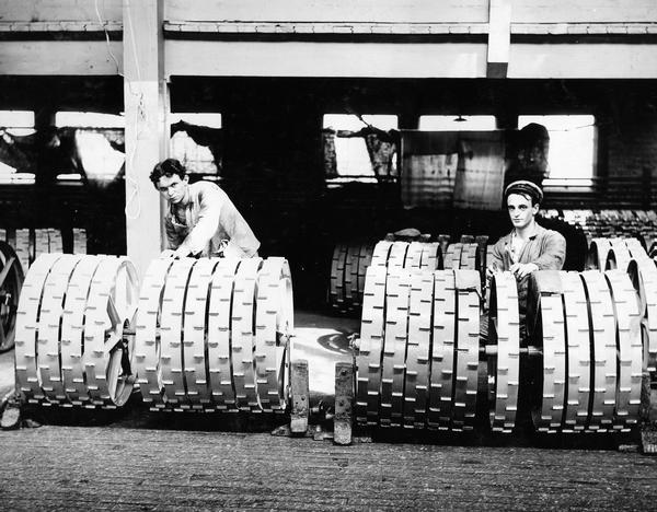 Two workmen inspecting mower wheels at International Harvester's Deering Works.  The Deering Works was originally built by William Deering for the Deering Harvester Company in 1880. In 1902 it became International Harvester's Deering Works. The factory was located at Fullerton and Clybourn Avenues and closed in 1933.