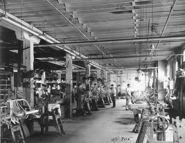 Men assembling binders at International Harvester's Deering Works (factory). The factory was originally built by William Deering for the Deering Harvester Company in 1880. In 1902 it became International Harvester's Deering Works. The factory was located at Fullerton and Clybourn Avenues and closed in 1933.